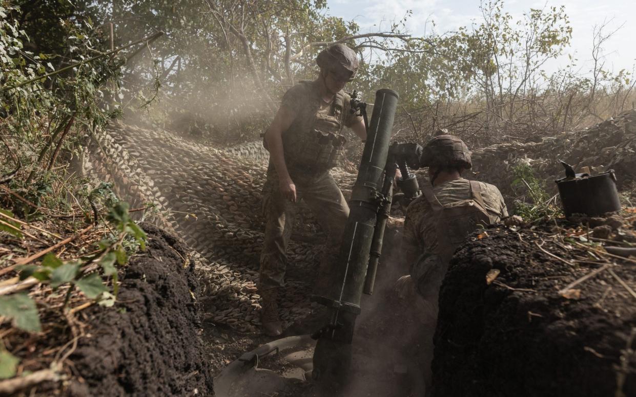 Ukrainian soldiers fire a mortar at Russian positions near Kreminna, August 26