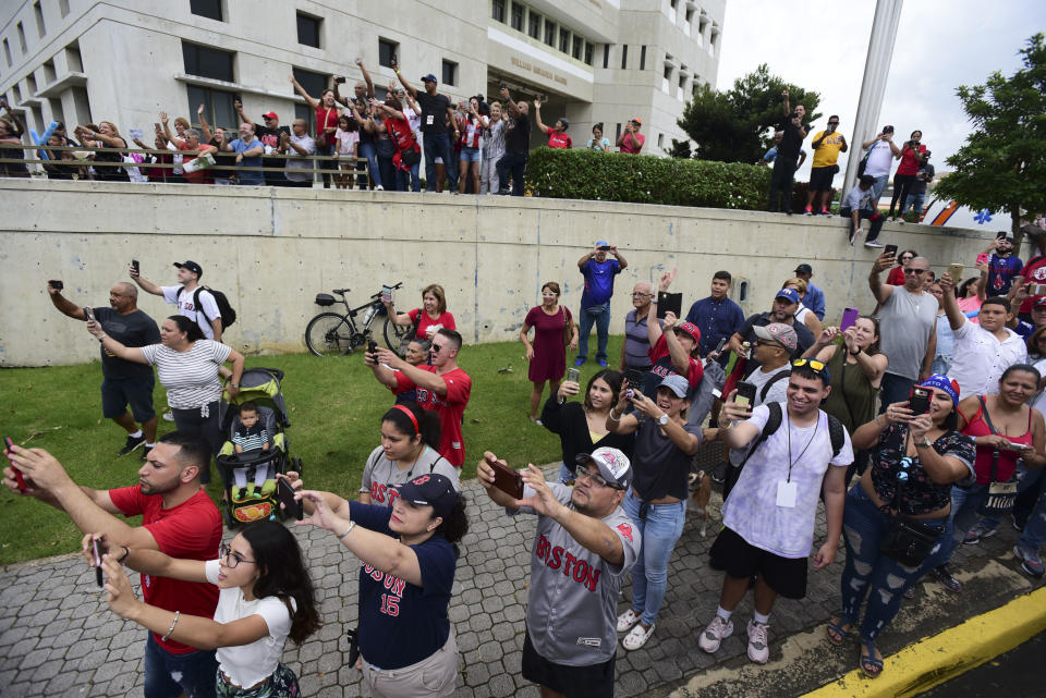 Fan take pictures and film with their mobile phones as Boston Red Sox manager Alex Cora arrives at his hometown with the 2018 World Series trophy, accompanied by Chairman Tom Werner and President and CEO Sam Kennedy, as well as seven Red Sox players and coaches, in Caguas, Puerto Rico, Saturday, Nov. 3, 2018. (AP Photo Carlos Giusti)
