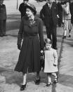 The future Queen Elizabeth II with a young Prince Charles at London Airport.