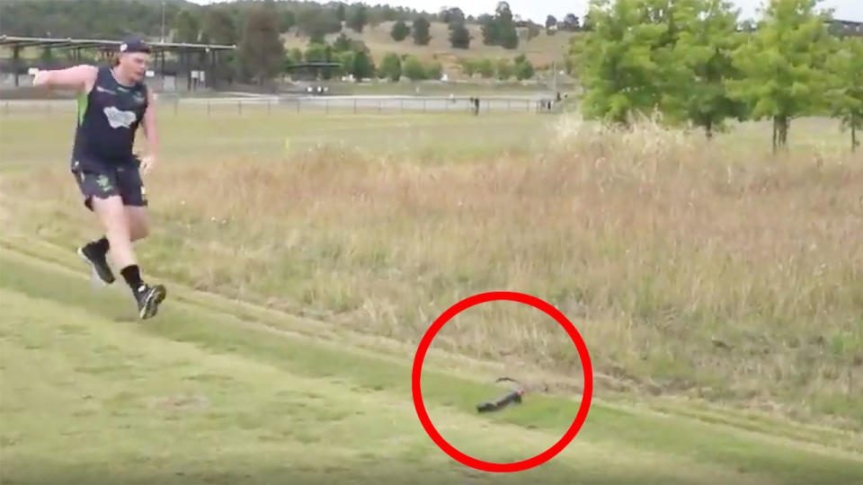 A Raiders player can be seen jumping in shock at the sight of the fake snake.