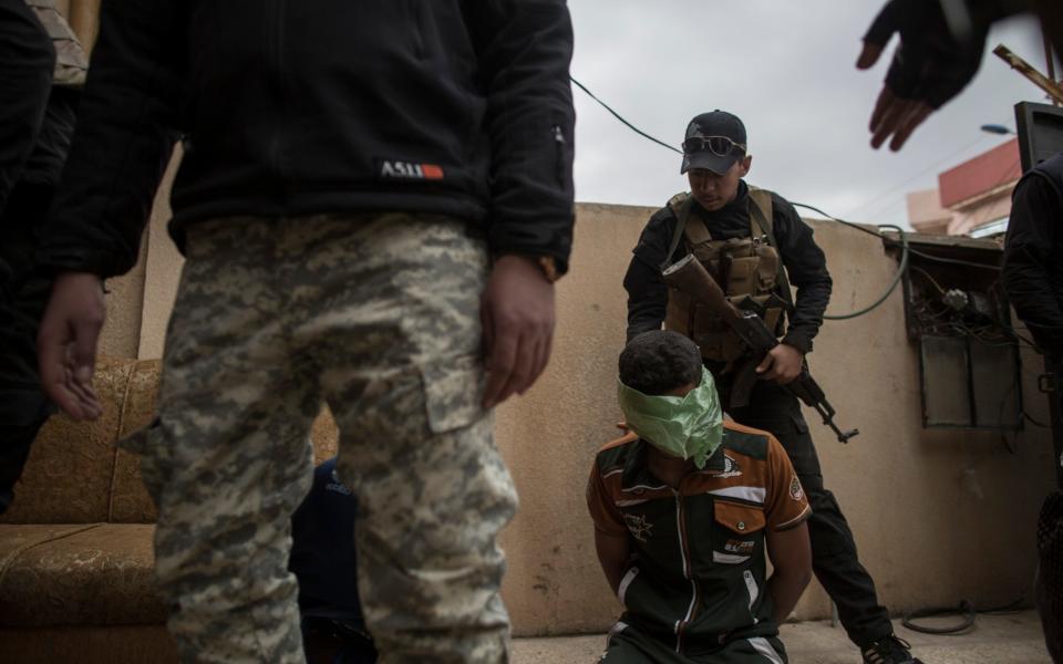 Members of the Iraqi National Security Service guard a suspected ISIS collaborator at their base in Bartella, near Mosul,  - Sam Tarling