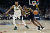 Denver Nuggets forward Will Barton (5) drives to the basket against Milwaukee Bucks guard George Hill (3) during the second quarter of an NBA basketball game Friday, Nov. 26, 2021, in Denver. (AP Photo/Jack Dempsey)