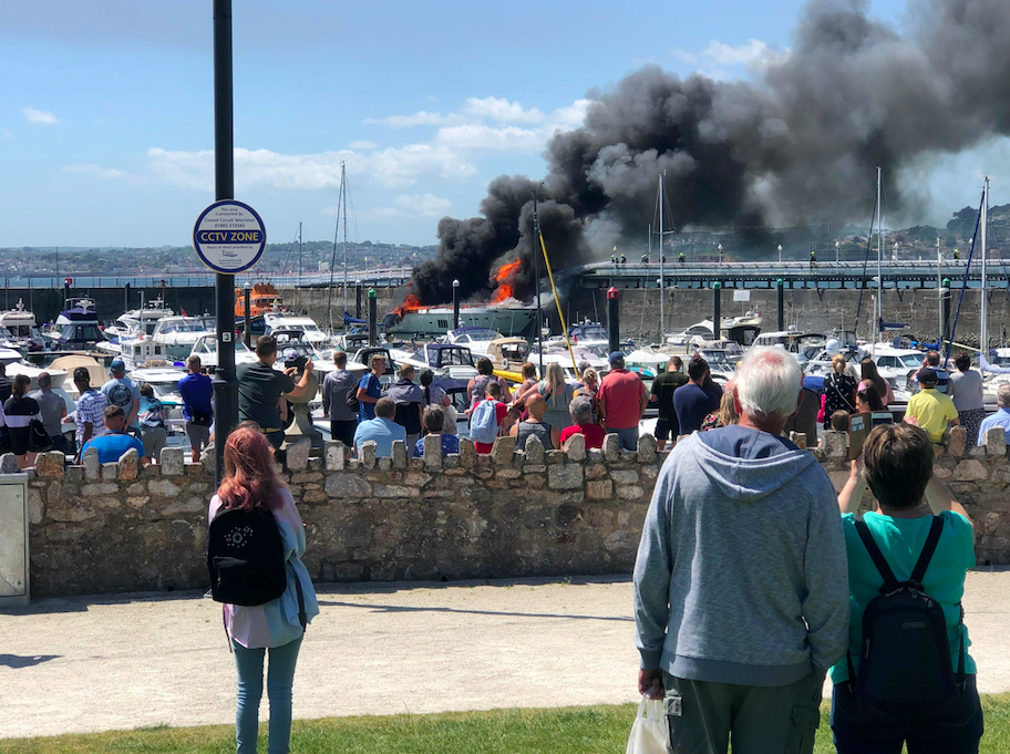 Smoke was seen billowing across the blue skies above the heads of bemused sunbathers during the fire. (SWNS)