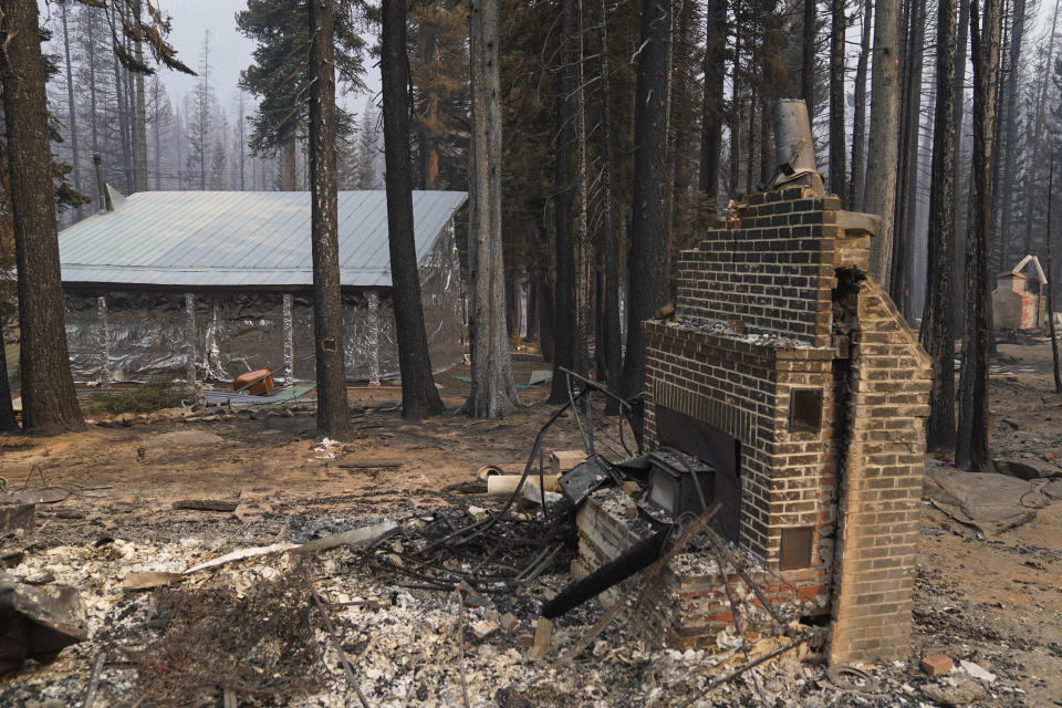 FILE - In this Sept. 2, 2021 file photo a cabin partially covered in fire-resistant material stands next to properties destroyed in the Caldor Fire in Twin Bridges, Calif. Aluminum wraps designed to protect homes from flames are getting attention as wildfires burn in California. (AP Photo/Jae C. Hong,File)