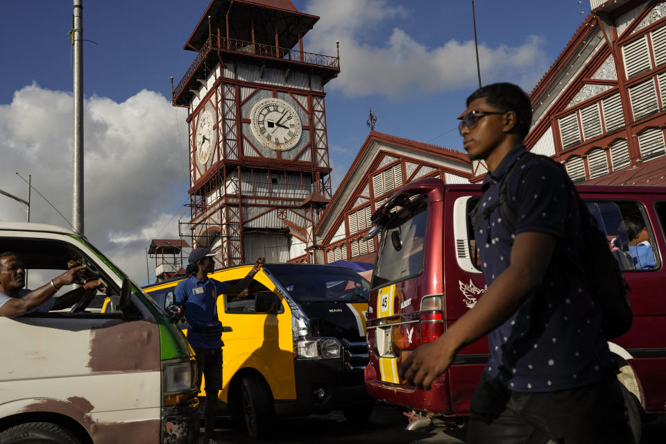 Drivers are stuck in traffic near the Stabroek Market in Georgetown, Guyana, Thursday, April 13, 2023. Despite the nation's oil boom, poverty is deepening for some as the cost of living soars, with goods such as sugar, oranges, cooking oil, peppers and plantains more than doubling in price while salaries have flatlined. (AP Photo/Matias Delacroix)