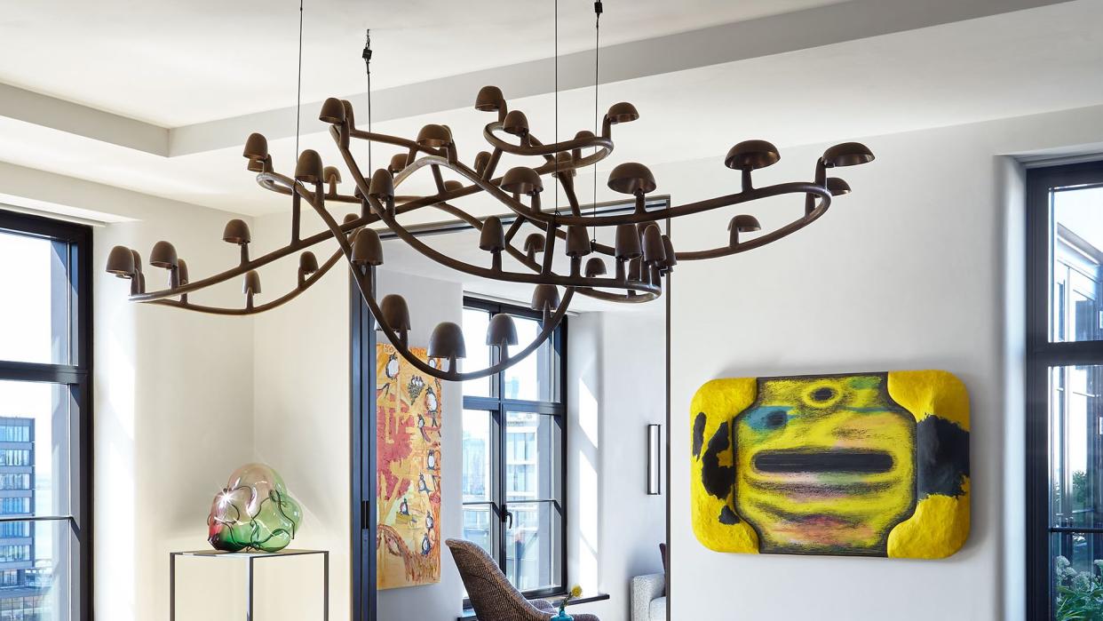 a dining room area with a chandelier hanging above and artwork