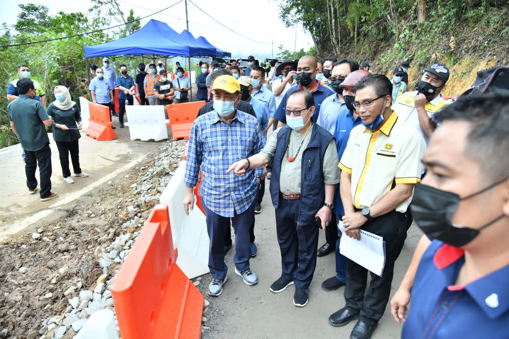 Sabah Chief Minister Datuk Seri Hajiji Noor (left) observes repair work on a damaged stretch of road between Penampang and Tambunan January 26, 2021. — Picture by Julia Chan