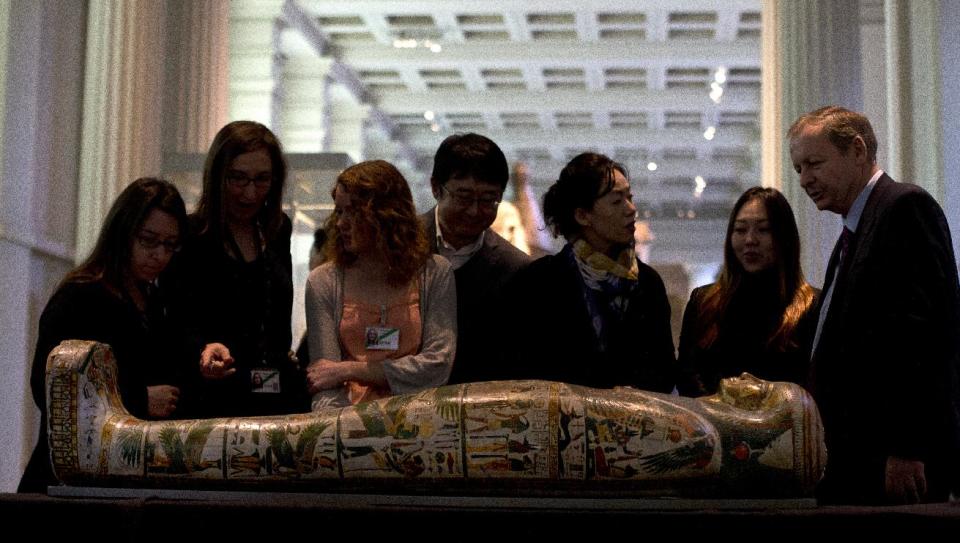 Members of the media stand around the Mummy of Tamut, a temple singer around 900 BC, during a press conference at the British Museum in London, Wednesday April 9, 2014. Scientists at the British Museum have used CT scans and volume graphics software to go beneath the bandages, revealing the skin, bones, internal organs, and in one case a brain-scooping rod left inside a skull by embalmers. The results are going on display in an exhibition which sets eight of the museum's mummies alongside detailed 3-D images of their insides. (AP Photo/Alastair Grant)