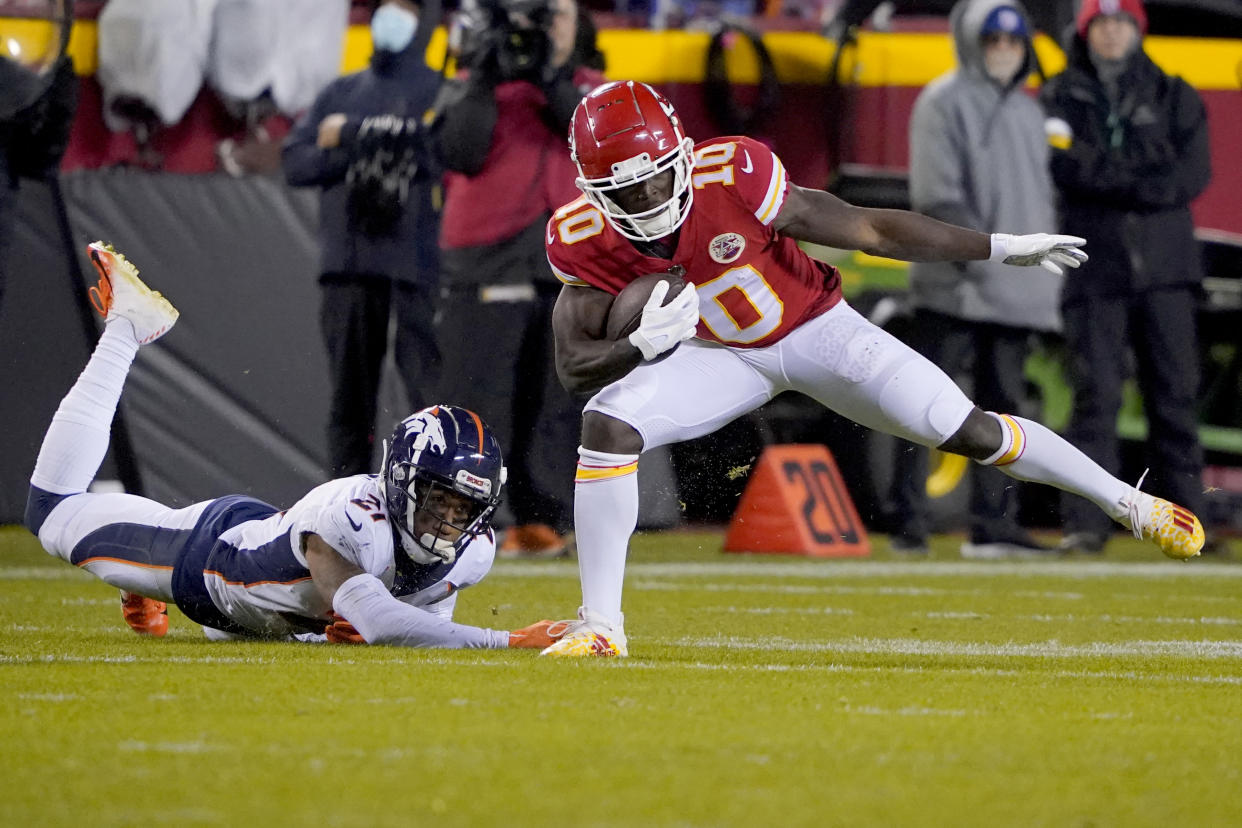 Kansas City Chiefs wide receiver Tyreek Hill (10) runs with the ball as Denver Broncos cornerback Ronald Darby (21) defends during the second half of an NFL football game Sunday, Dec. 5, 2021, in Kansas City, Mo. (AP Photo/Ed Zurga)