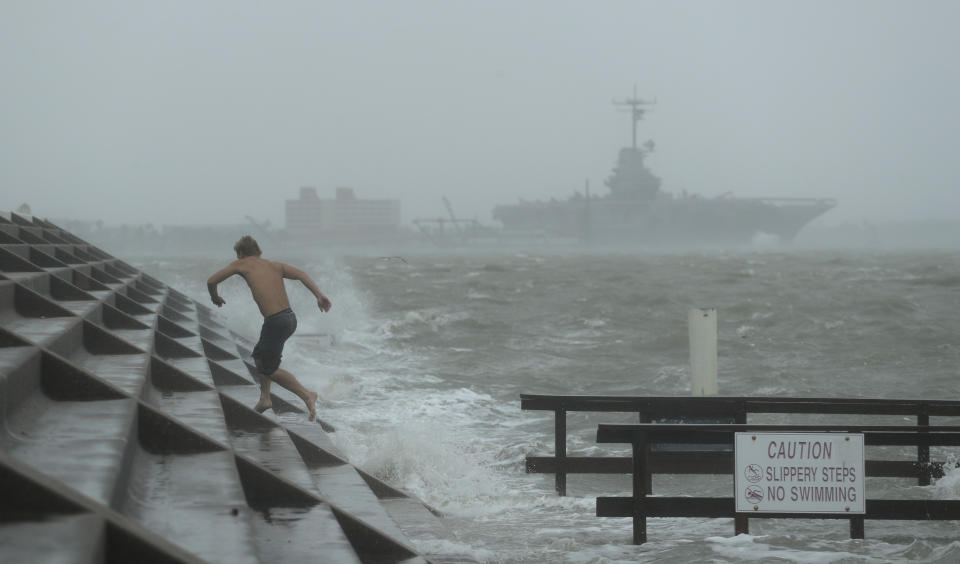 A man jumps from a wave as Hurricane Hanna begins to make landfall, Saturday, July 25, 2020, in Corpus Christi, Texas. The National Hurricane Center said Saturday morning that Hanna's maximum sustained winds had increased and that it was expected to make landfall Saturday afternoon or early evening.(AP Photo/Eric Gay)