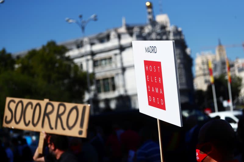 A demonstrator holds a banner reading in Spanish "Help!" during a protest in Madrid