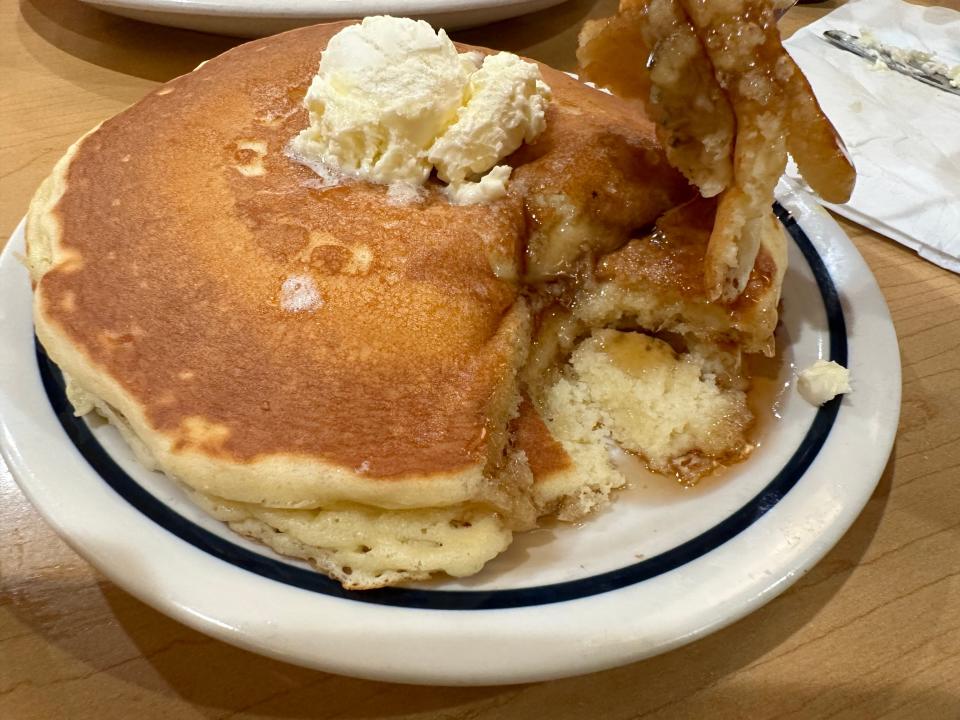 two pancakes at ihop with syrup on white plate
