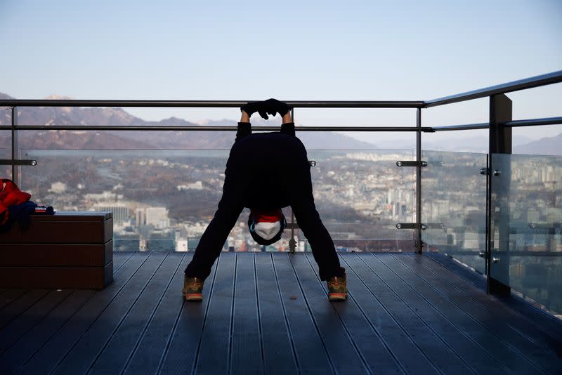 A woman stretches on the top of Mt. Nam amid the coronavirus disease (COVID-19) pandemic in Seoul