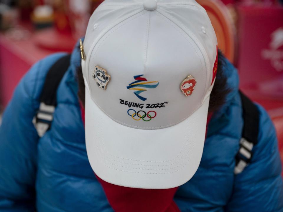 A customer wears a Beijing 2022 hat with pins of mascots Bing Dwen Dwen and Shuey Rhon Rhon as she shops at the official Beijing 2022 Winter Olympics flagship souvenir store on February 8, 2022 in Beijing, China. Crowds of people have been lining up at authorized Beijing 2022 Winter Olympic stores trying to purchase Bing Dwen Dwen paraphernalia, the panda mascot of the Games. Items featuring the character have become a hot seller that Beijing 2022 merchandise stores cannot keep them in stock. Officials say the factories authorized to produce the souvenirs have been urged to increase production to help boost supplies. The sudden popularity of Bing Dwen Dwen, along with the Paralympic Games mascot Shuey Rhon Rhon, comes as most Chinese fans are unable to attend Olympics events in the host city because of China's zero-COVID protocols.