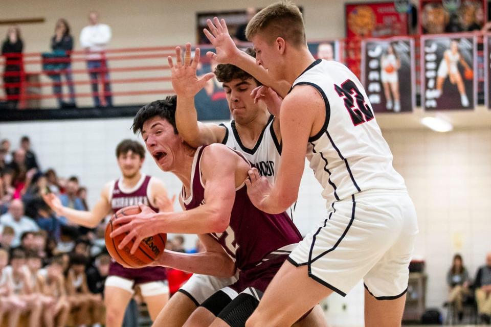Mishawaka's Cooper Pritchett (12) gets fouled by NorthWood's Seth Russell (33) as Tyler Raasch (22) also defends during the Mishawaka vs. NorthWood boys basketball game Friday, Feb. 9, 2024 at NorthWood High School in Nappanee.