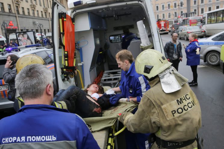 An injured person is helped by emergency services outside Sennaya Ploshchad metro station in St. Petersburg, Russia