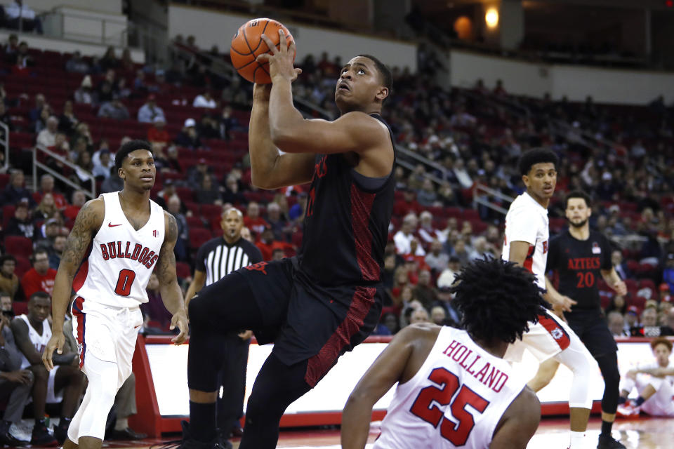 San Diego State's Matt Mitchell drives to the basket next to Fresno State's Anthony Holland, right, during the first half of an NCAA college basketball game in Fresno, Calif., Tuesday Jan. 14, 2020. (AP Photo/Gary Kazanjian)