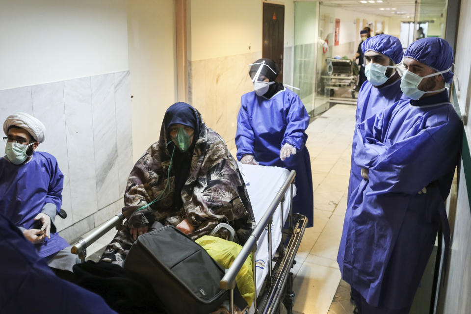 FILE - In this March 7, 2020 file photo, a patient infected with the new coronavirus is moved, at Baqiyatallah Al'Azam Hospital that is affiliated to the Revolutionary Guard, in Tehran, Iran. While crippling sanctions imposed by the U.S. government left the country ill-equipped to deal with the fast-moving virus, some medical professionals say government and religious leaders bear the brunt of the blame for allowing the virus to spread -- and for hiding how much it had spread. (Mohammad Hasan Zarifmanesh/Tasnim News Agency via AP, File)