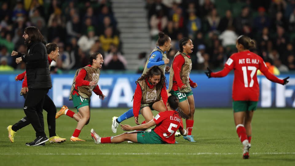 Morocco's head coach Reynald Pedros (left) and his players celebrate after advancing to the round of 16. - Gary Day/AP