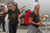 Members of the United States women's soccer team, winners of a fourth Women's World Cup, celebrate after arriving at Newark Liberty International Airport, Monday, July 8, 2019, in Newark, N.J. From left to right, Megan Rapinoe, Alex Morgan and Julie Ertz, holding the trophy. (AP Photo/Kathy Willens)