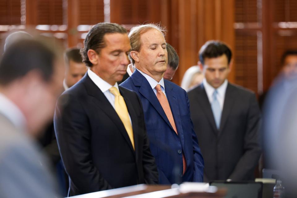 (From left) Paxton's attorney Tony Buzbee stands with Texas Attorney General Ken Paxton as Texas Sen. Phil King (not pictured) says the prayer at the beginning of the first day of Paxton’s impeachment trial in the Texas Senate chambers at the Texas State Capitol in Austin on Tuesday, Sept. 5, 2023. The Texas House, including a majority of its GOP members, voted to impeach Paxton for alleged corruption in May. (Juan Figueroa/Pool via The Dallas Morning News)