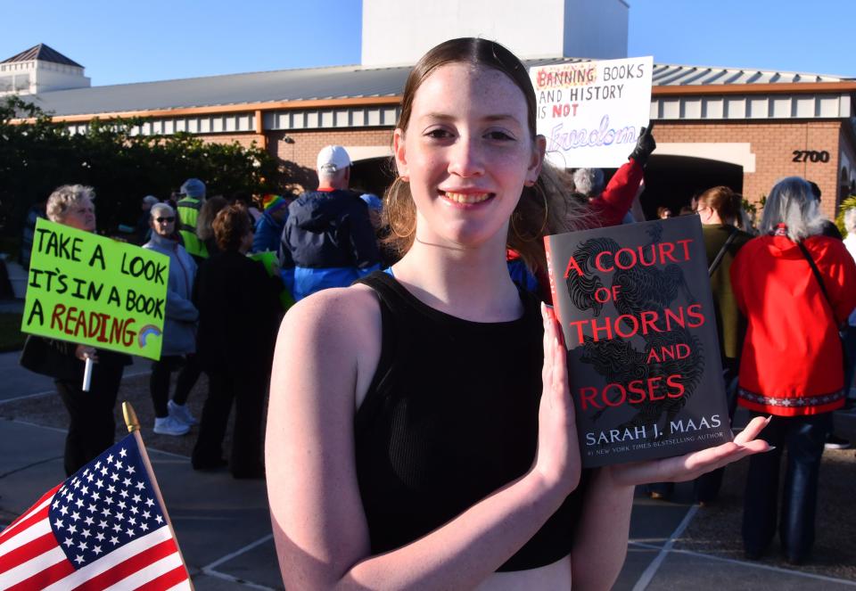 Eighth-grade student Allison Kervin shows a copy of “A Court of Thorns and Roses,” a book on the agenda at a Feb. 6 Brevard school board meeting, at a pre-meeting rally against book banning organized by Brevard Students for Change.