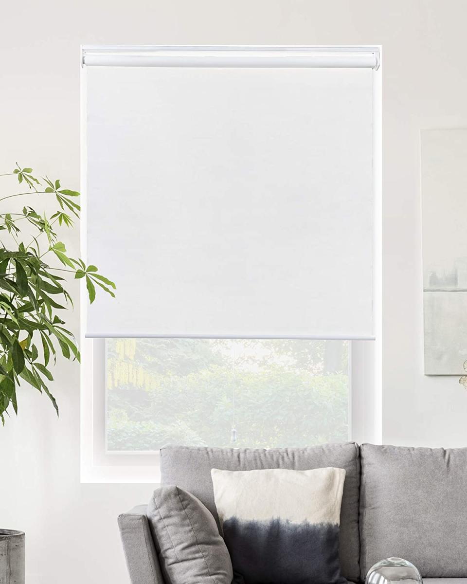 White roller blind behind a couch