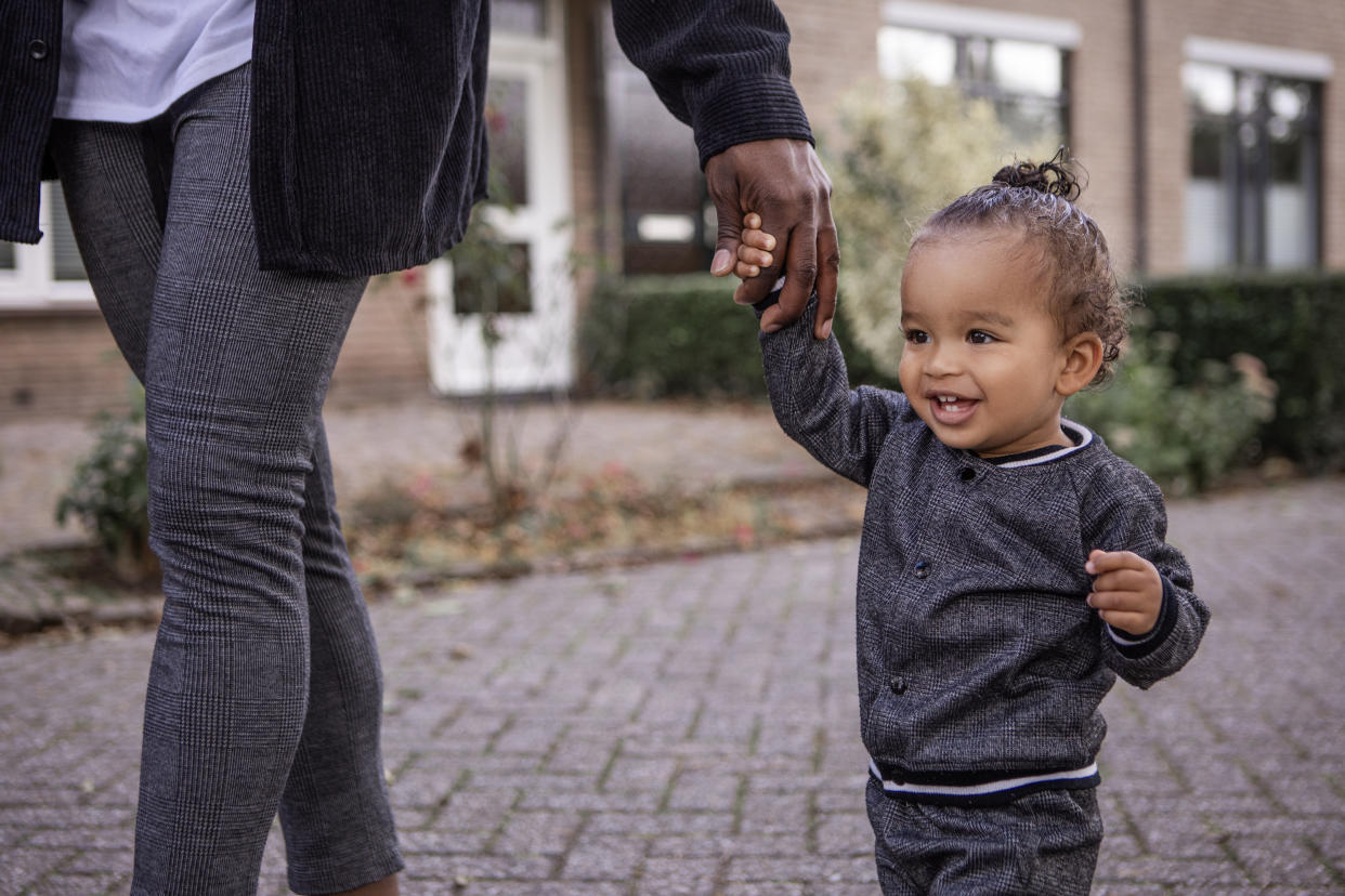 Handsome black father having fun exploring the neighbourhood with his toddler son