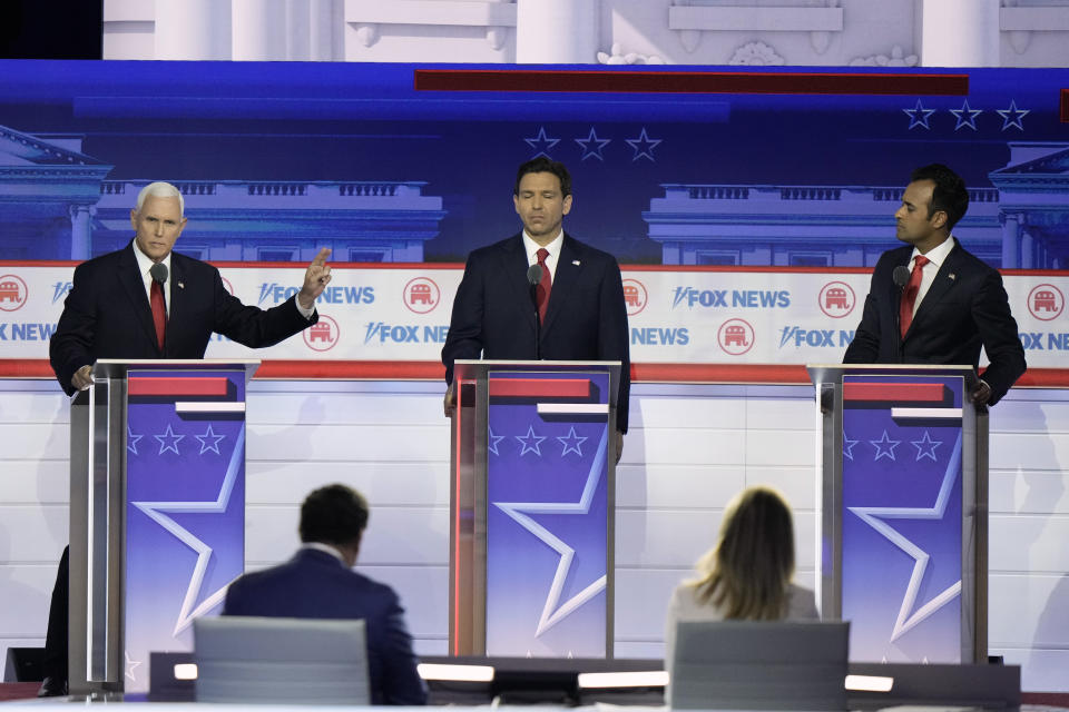 Former Vice President Mike Pence speaks as Florida Gov. Ron DeSantis and businessman Vivek Ramaswamy listen during a Republican presidential primary debate hosted by FOX News Channel Wednesday, Aug. 23, 2023, in Milwaukee. In the foreground are moderators Brett Baier and Martha MacCallum. (AP Photo/Morry Gash)