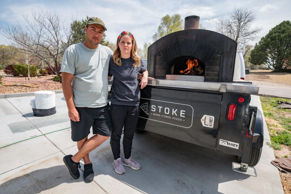 Stoke Pizza owners Wes and Bre Latka stand with their wood-fired pizza oven trailer. The couple's previous oven trailer was stolen in September.