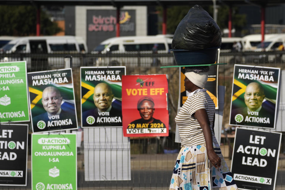 A woman walks past election posters in Tembisa, east of Johannesburg, South Africa, Tuesday, May 28, 2024, ahead of the elections on Wednesday May 29. (AP Photo/Themba Hadebe)