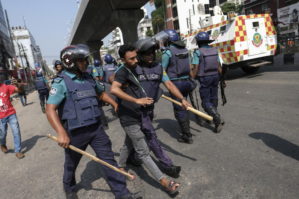 Bangladesh police detain a man as they disperse Bangladeshi garment factory workers who were blocking traffic demanding better wages at Dhaka-Mirpur area in Bangladesh, Thursday, Nov.2, 2023. (AP Photo/Mahmud Hossain Opu)