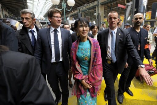 Myanmar pro-democracy leader Aung San Suu Kyi (C) is surrounded by Pascal Canfin (2nd L) , French Minister Delegate for Development as she arrives at the train station gare du Nord in Paris