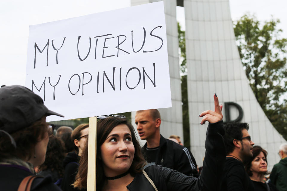 Another young woman protesting with sign in front of the Polish Parliament in Warsaw.