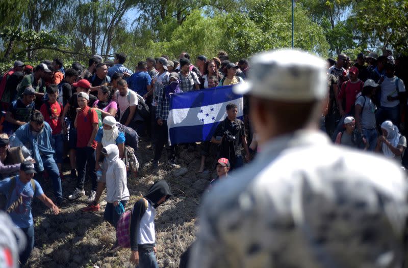 A member of Mexico's National Guard blocks migrants, part of a caravan travelling to the U.S., near the border between Guatemala and Mexico, in Ciudad Hidalgo