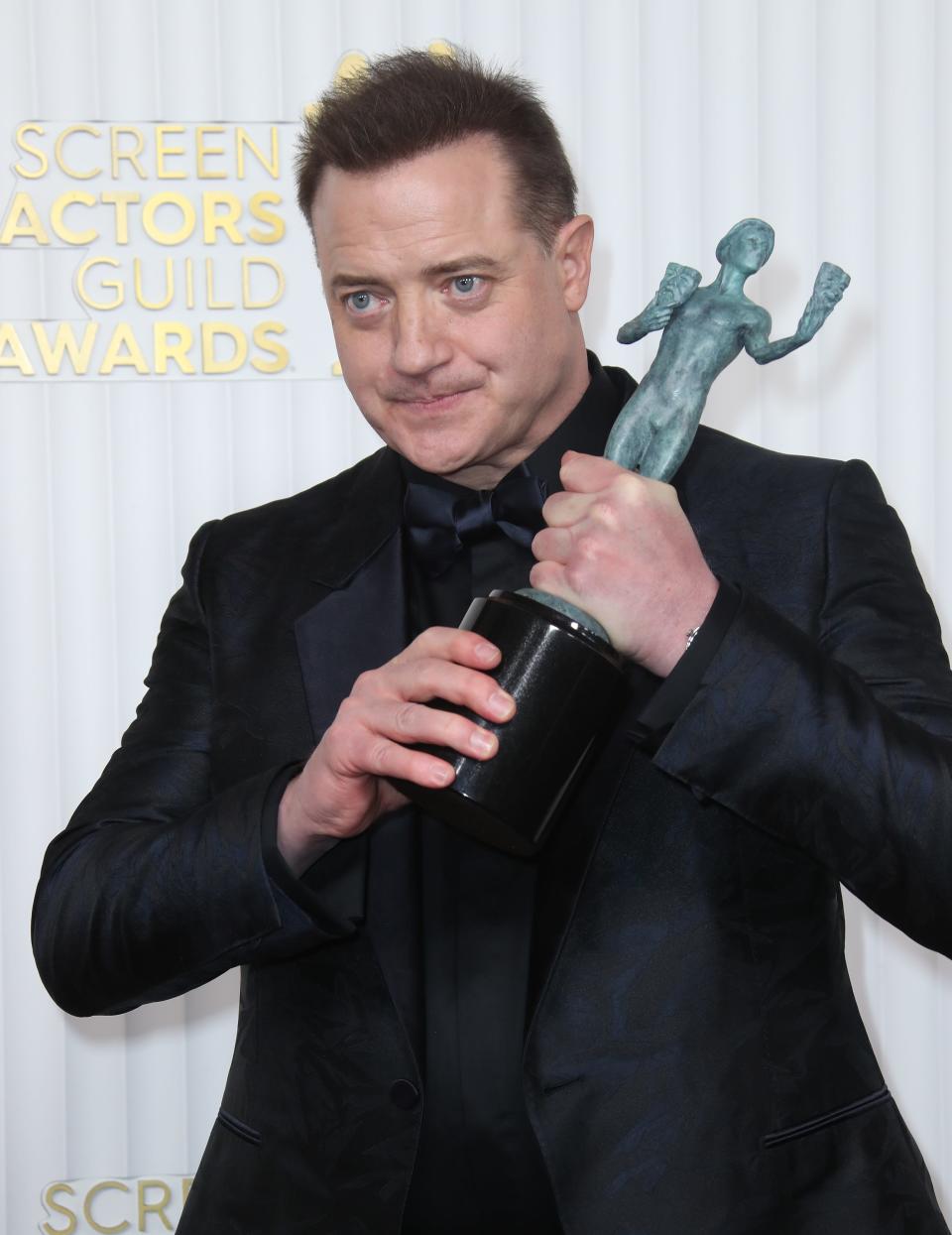 Brendan Fraser hoists his SAG Award trophy after winning best actor for "The Whale."