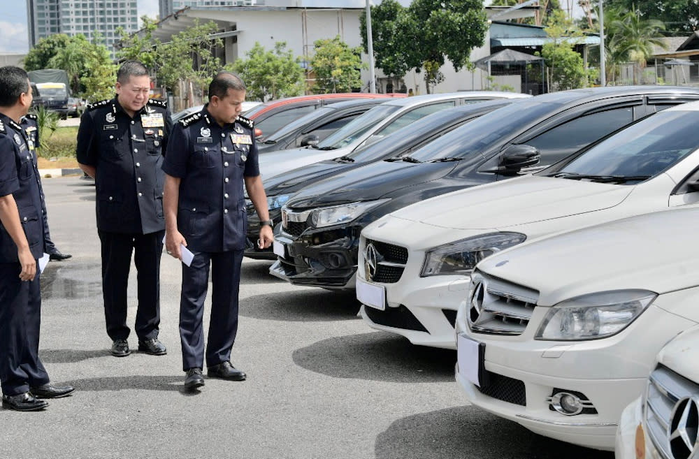 Johor police chief Datuk Ayob Khan Mydin Pitchay inspecting the seized cars from the drug syndicate at the Johor police contingent headquarters May 11, 3030.  — Picture by Ben Tan