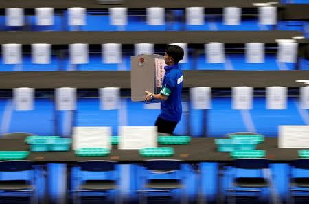 An election official runs as he carries an unopened ballot box for Japan's lower house election at a counting centre in Tokyo, Japan, October 22, 2017. EUTERS/Issei Kato