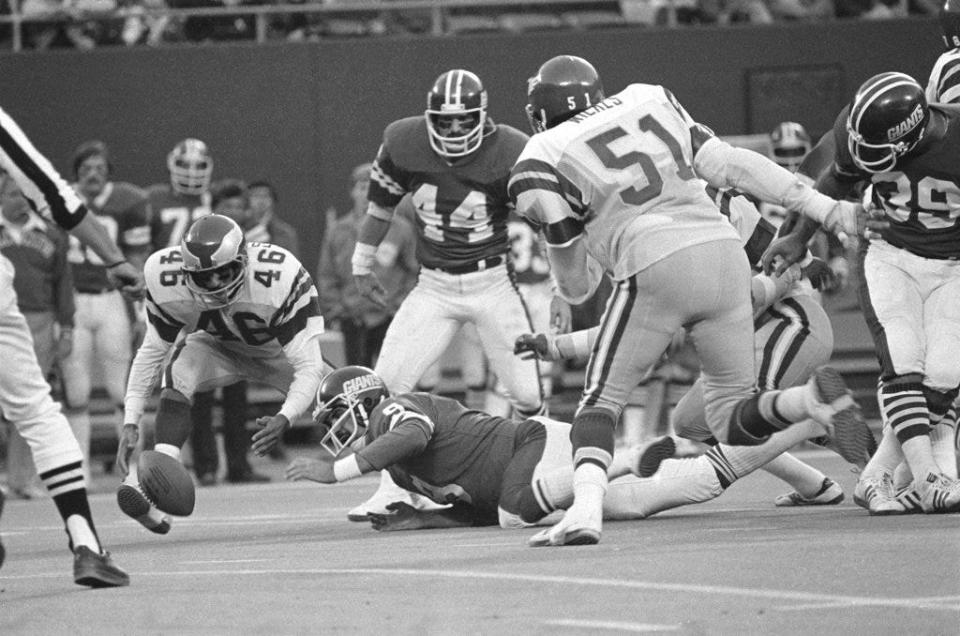 FILE - In this Nov. 19, 1978, file photo, Herman Edwards (46) of the Philadelphia Eagles pounces on the ball fumbled by New York Giants quarterback Joe Pisarcik (9) during the last minutes of an NFL football game in East Rutherford, N.J. The ball was fumbled during a botched handoff between Pisarcik and Larry Csonka (39), far right. Edwards scored on the play and the Eagles won 19-17. (AP Photo/G. Paul Burnett, File)