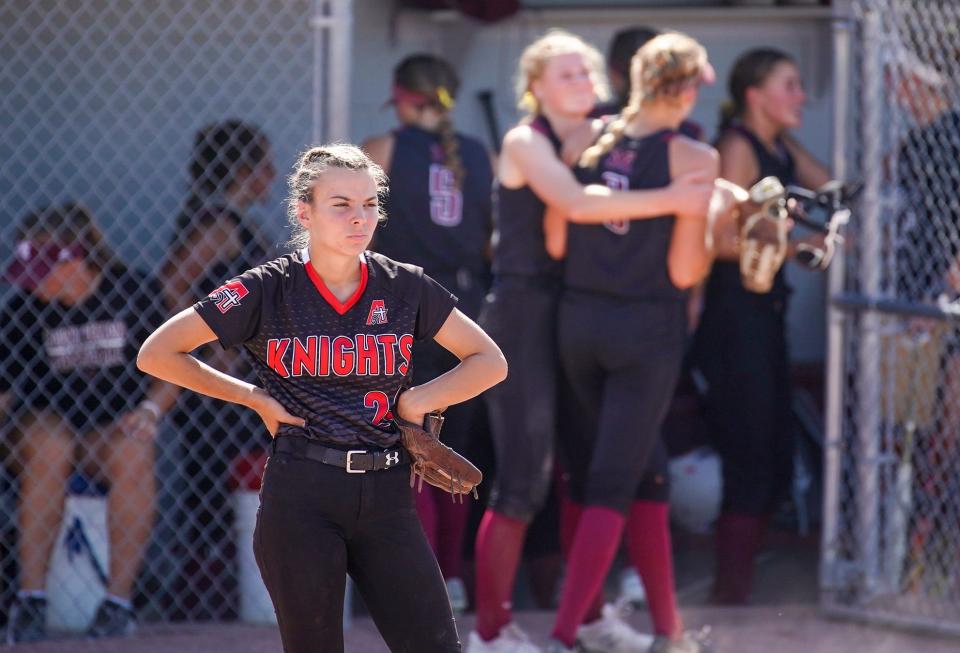 Assumption's Jessie Wardlow (2) stands on the field as Mount Vernon players celebrate a run scored behind her during the Class 3A softball state championship at the Harlan Rogers Sports Complex on Friday in Fort Dodge.