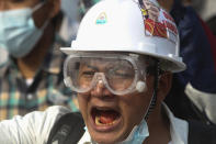 A protester wears a safety helmet and eye protector as he shouts slogans during a protest against a military coup in Yangon, Myanmar, Sunday, Feb. 28, 2021. In the month since Feb. 1 coup, the mass protests occurring each day are a sharp reminder of the long and bloody struggle for democracy in a country where the military ruled directly for more than five decades. (AP Photo)