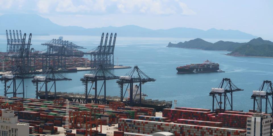 An aerial view, from land, of Yantian port in Shenzhen, China, showing a cargo ship approaching.