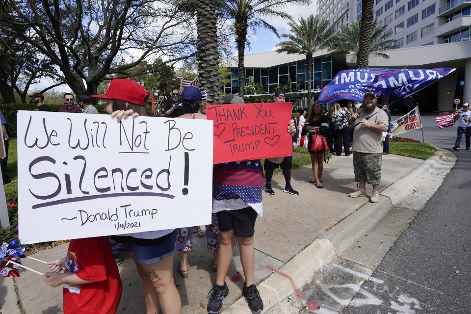 Trump supporters hold signs and wave to motorists outside the convention center at the Conservative Political Action Conference (CPAC) Saturday, Feb. 27, 2021, in Orlando, Fla. (AP Photo/John Raoux)