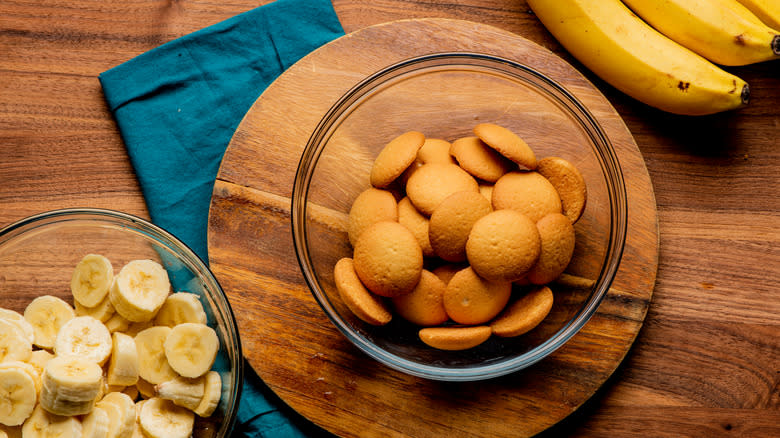 Glass bowl of vanilla wafers next to glass bowl of bananas