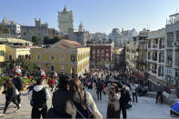 Travelers from mainland China gather near the Ruins of St. Paul's, a tourist destination in Macao, Wednesday, Jan. 18, 2022. A hoped for boom in Chinese tourism over next week's Lunar New Year holidays looks set to be more of a blip as most travelers avoid traveling overseas, if at all. (AP Photo/Kanis Leung)