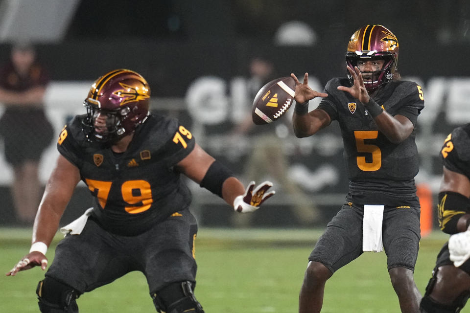 Arizona State quarterback Jaden Rashada (5) takes the snap from offensive lineman Leif Fautanu (79) during the first half of the team's NCAA college football game against Oklahoma State on Saturday, Sept. 9, 2023, in Tempe, Ariz. (AP Photo/Ross D. Franklin)