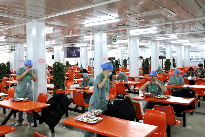 Trabajadores de la salud comen en mesas separadas en un restaurante dentro del Hospital Xiaotangshan en Pekín