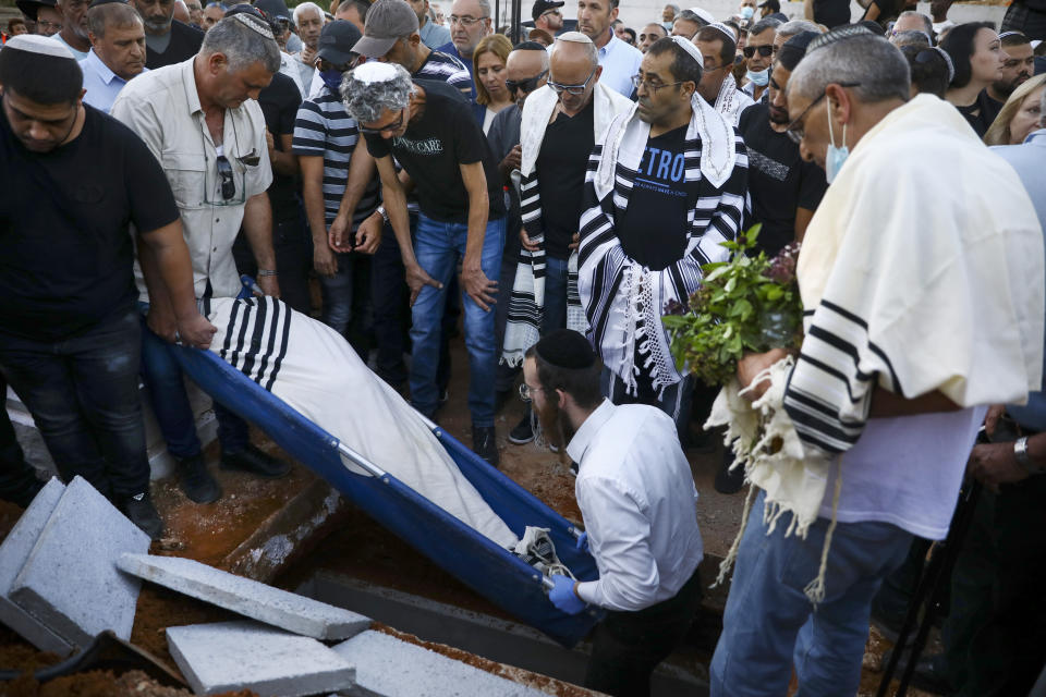 FILE - In this May 18, 2021 file photo, mourners attend the funeral of Yigal Yehoshua, 56, at a cemetery in Hadid, central Israel. Yehoshua was a Jewish man who died May 17 after being pelted with rocks amid clashes between Arabs and Jews in Israel’s mixed city of Lod. Randa Aweis, a 58-year-old Arab mother of six, got one of Yehoshua’s kidneys after a 10-year wait, in a rare moment of hope after days and nights of war and ugliness. (AP Photo/Oded Balilty, File)