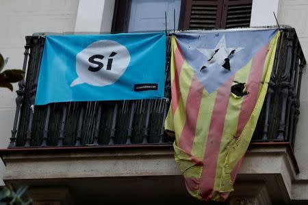 A damaged Estelada (Catalan flag of independence) hangs from a balcony in Barcelona, Spain, October 20, 2017. REUTERS/Gonzalo Fuentes