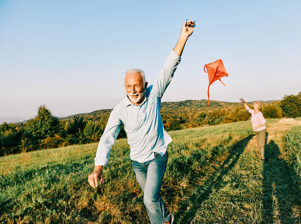 Happy active senior couple with kite outdoors